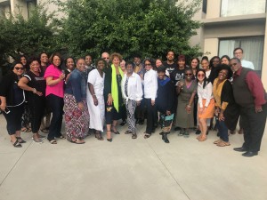 a large group of people are standing and smiling at the camera. 